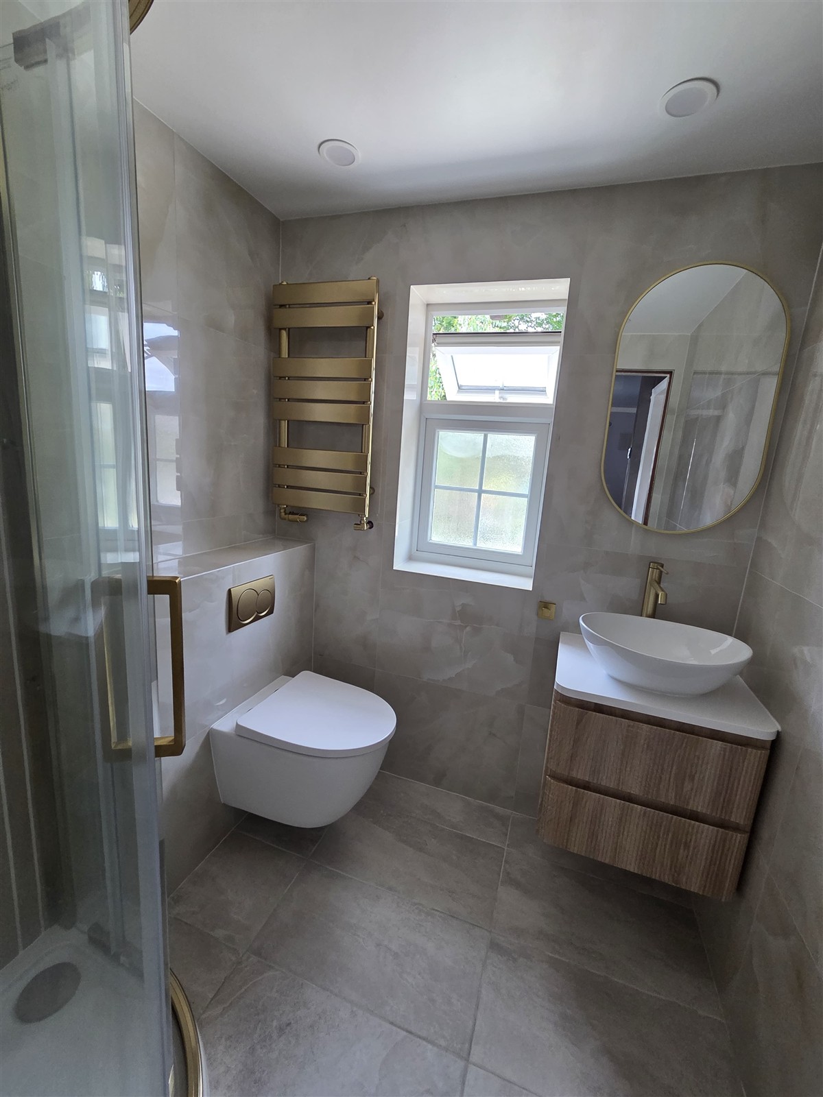 NEPTI bathroom refurbishment with stone-effect tiles, gold fittings and a floating wood vanity