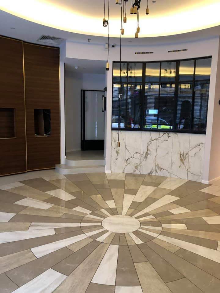 Decorative floor tiles arranged in a radial pattern, with marble-effect wall cladding