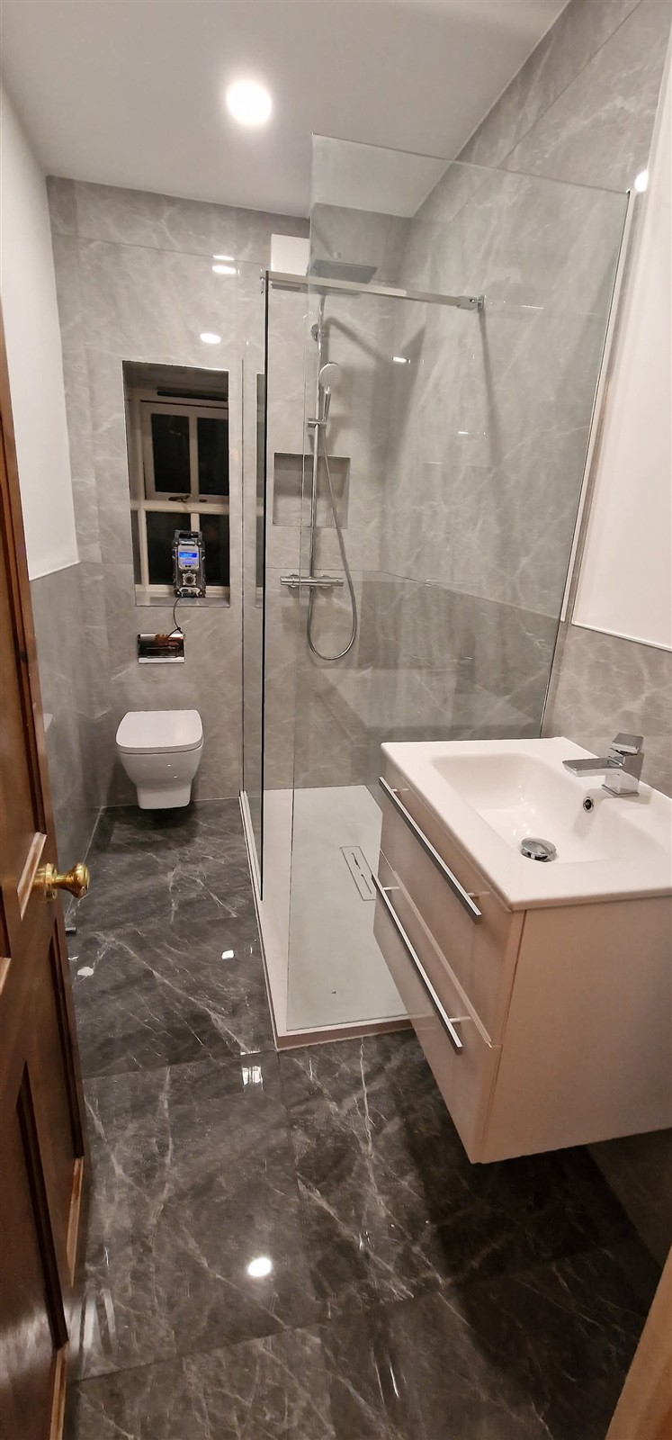 Bathroom with marble-effect tiling, glass shower and fitted vanity